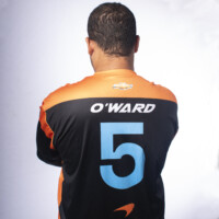 The back of a man wearing a jersey of the McLaren racing team and their driver Pato O'Ward