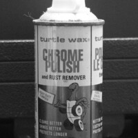 A monochrome photo of a very old can of chrome polish